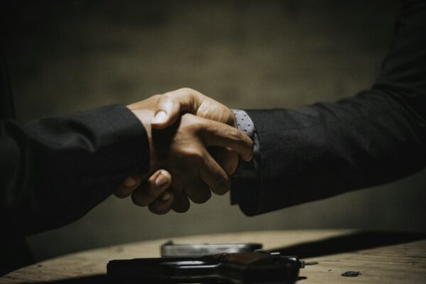 Two people shaking hands over a business deal