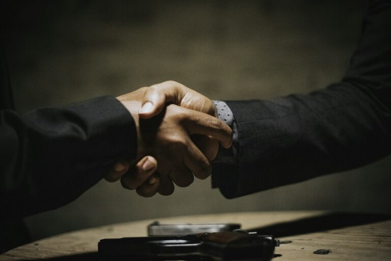 Two people shaking hands over a business deal